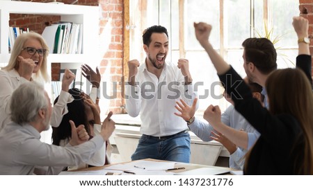 Euphoric excited business team celebrate corporate victory together in office, happy overjoyed professionals group rejoice company victory, teamwork success win triumph concept at conference table Royalty-Free Stock Photo #1437231776