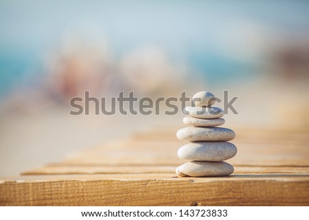 zen stones on wooden banch on the beach near sea. Outdoor. en style path on vintage wood table in relaxing wellness holistic spa for relaxation and good health rejuvenation