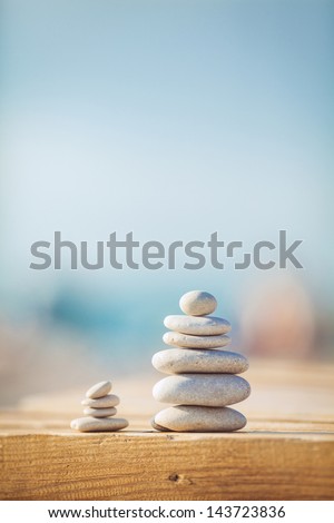 zen stones on wooden banch on the beach near sea. Outdoor. en style path on vintage wood table in relaxing wellness holistic spa for relaxation and good health rejuvenation Royalty-Free Stock Photo #143723836
