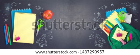 Back to school concept with bag backpack, notebook and school supplies over chalkboard background. Top view from above Royalty-Free Stock Photo #1437290957