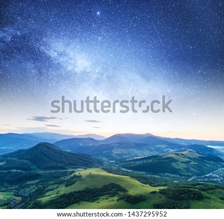 Starry sky against a mountain landscape in the evening.