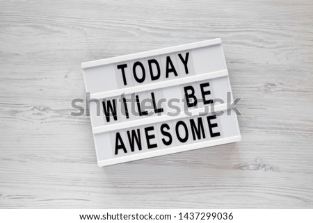 'Today will be awesome' words on a lightbox over white wooden background, overhead view. Flat lay, from above, top view.
