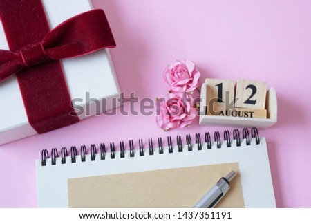 set of 12th august wooden calendar, empty diary, gift box on pink background with copy space, mother's day in thailand, love mom concept