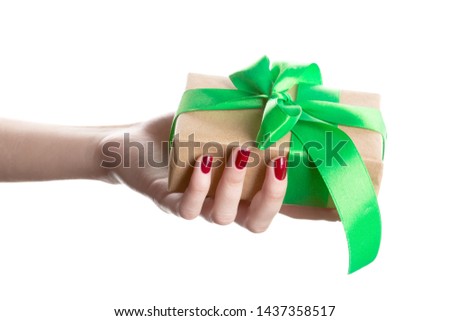 Hand woman holding gift box on isolated on white background. Gift wrap craft paper and green ribbon.