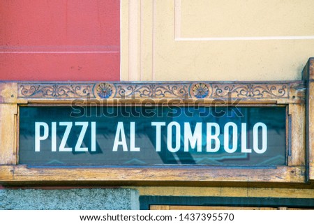 Close-up of an old shop sign that said "tombolo laces", a typical handmade fabric very popular in the Ligurian Riviera, Rapallo, Genoa, Liguria, Italy