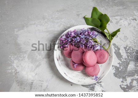 Macaroons near the lilac on a plate