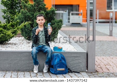 Cute school boy holding lunch box. Healthy eating concept for schoolchild.