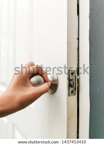 A hand grabbing knob for open the old door to into room
