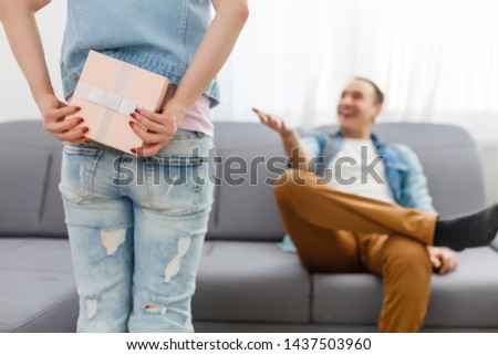 girl standing and holding white gift box behind his back