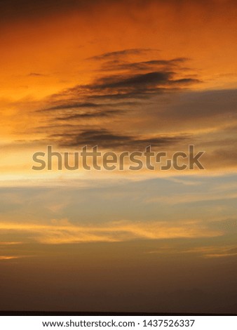 Sunset on a tropical island with orange clouds.