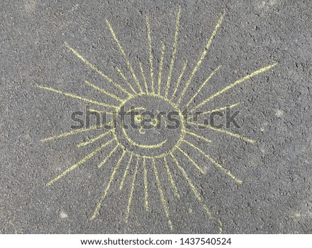 childish drawing sun colored chalk on asphalt close up