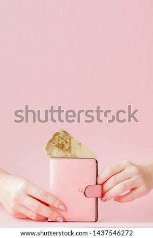 Kyiv, Ukraine - February 22, 2019: wallet and credit card in woman's hand on pink background.