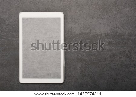 Digital tablet in a case on gray background with copy space