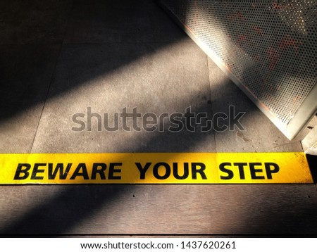 Sticker line of beware warning step closeup morning shadow