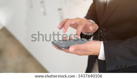 Communication and Technology Concept. Close up of man with smartphones at office.	