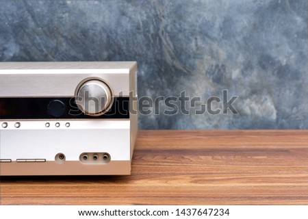 Half front side AV receiver with volume and AUX Plugin on wood table Royalty-Free Stock Photo #1437647234