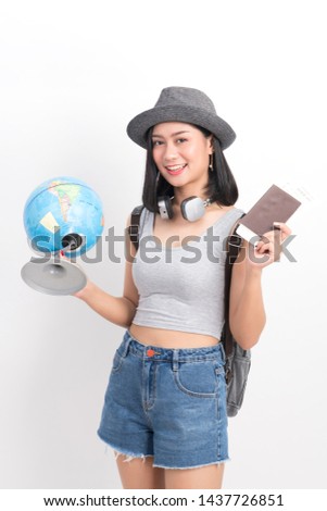 Asian girl tourists who hold one-handed world and passports with other tickets on a white background
