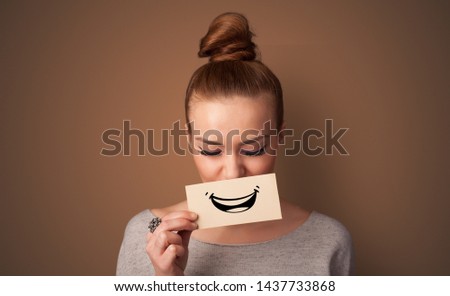 Person holding card in front of his mouth with ironic smile