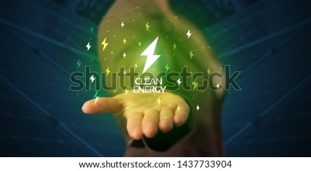 Hand in suit holding lightning bolt on his hand, green environment concept Royalty-Free Stock Photo #1437733904