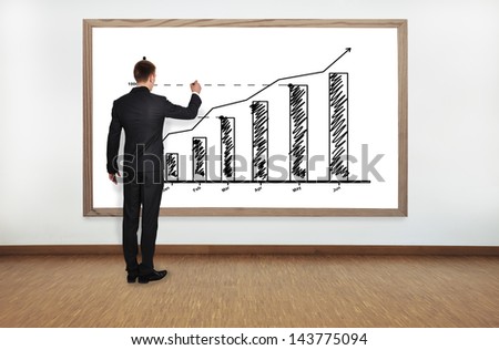 businessman drawing graph on blackboard