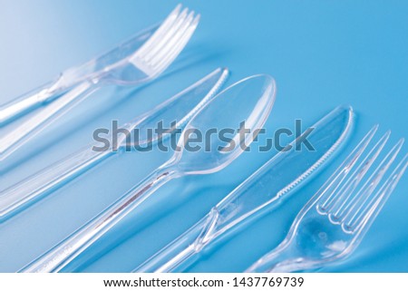 plastic forks and knifes on blue background. copy space Royalty-Free Stock Photo #1437769739