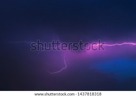 Thunderclouds with lightning in the night sky.