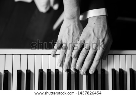 Groom and and bride hands with rings. On piano, close up