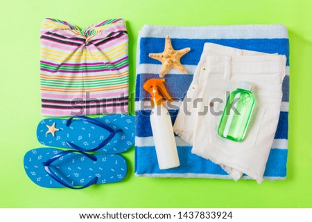 Flat lay composition with blue Beach accessories on green color background. Summer holiday background. Vacation and travel items top view.