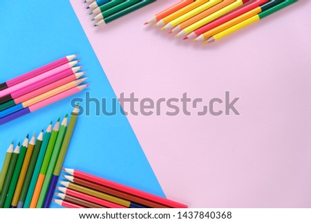 Creative flat lay back to school concept with colored pencils on blue and pink background. Minimal concept art. Top view, copy space.