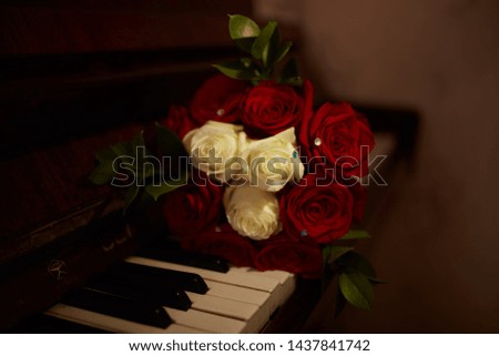 Wedding bouquet of red roses on the piano keys