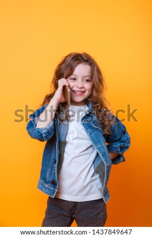 close-up of little smiling girl calling on smartphone. Technology and communication concept