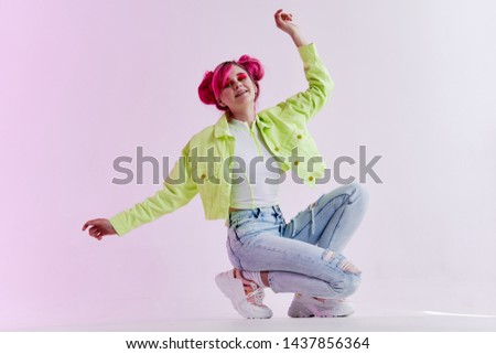 woman in a green jacket with pink hair squats