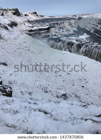 View of beautiful frozen Gullfoss waterfall in Iceland with ice and snow everywhere in winter with blue sky background.