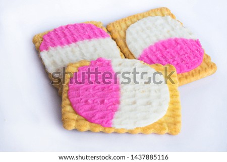 close up of square shape cream biscuits filled with white and pink cream  isolated on a white background.