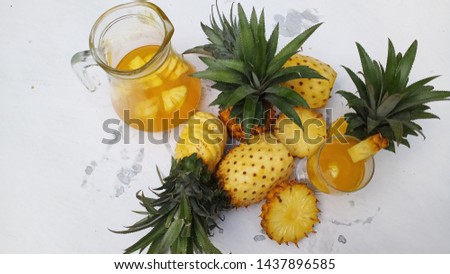 Delicious sweet pineapple juice drinks and fruit that is still intact on a white background