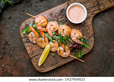 tiger shrimp kebab on the board on dark concrete rustic background