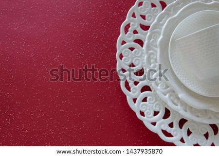 Top view of vintage tableware set on red background. Empty elegant porcelain plates 