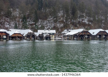 Scenery with lots of boathouses around Schoenau am Koenigssee in Bavaria at winter time Royalty-Free Stock Photo #1437946364