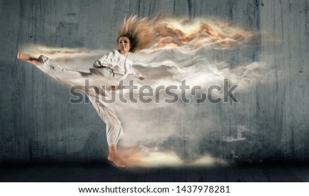Woman in kimono practicing taekwondo. Modern Korean martial art similar to karate Royalty-Free Stock Photo #1437978281