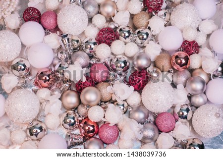 Pink, white and silver balls lie on a silver fabric. Many Christmas decorations. Preparing for the new year. Christmas decor