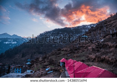 snow mountain with nice orange color clouds on sky with valley 