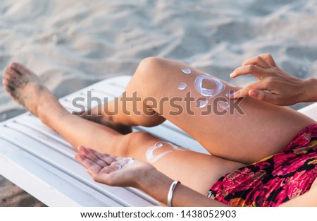 Woman using sun lotion on beach summer vacation
