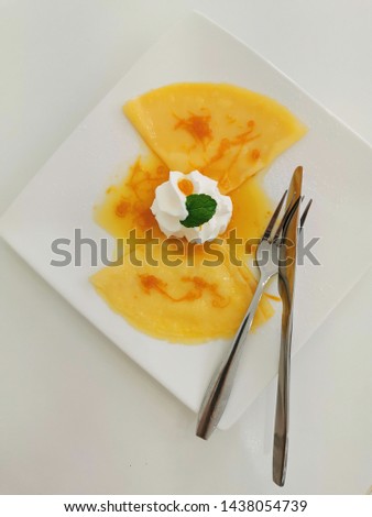 Crepe Suzette on white plate with silver knife and fork