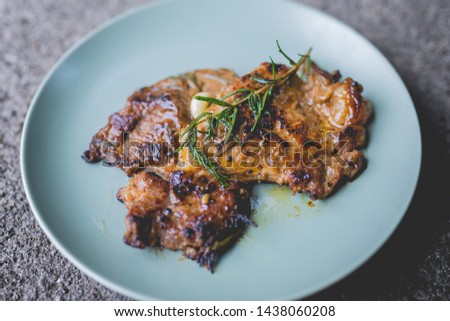 The picture of Round plate with grilled beef steak and rosemary