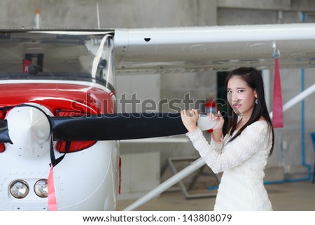 Woman standing in front of a light aircraft