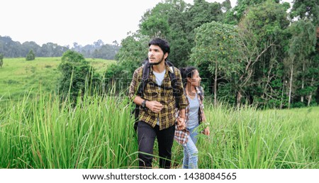 Asian Group of young people Hiking with friends backpacks walking together and looking map and taking photo camera by the road and looking happy ,Relax time on holiday concept travel