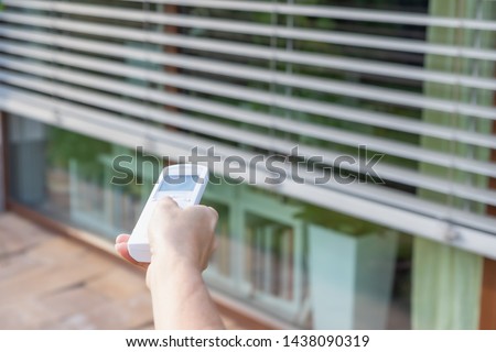 Control the external window blinds with the remote control. Vertically.  Royalty-Free Stock Photo #1438090319