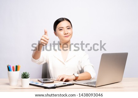 Happy woman showing thumb up at office isolated over background