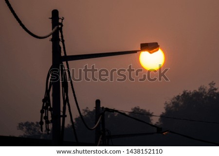 Silhouette of street lights during beautiful sunset at the lamp