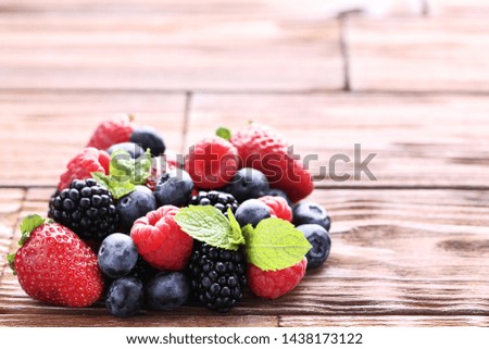 Ripe and sweet fruits with green leafs on brown wooden table